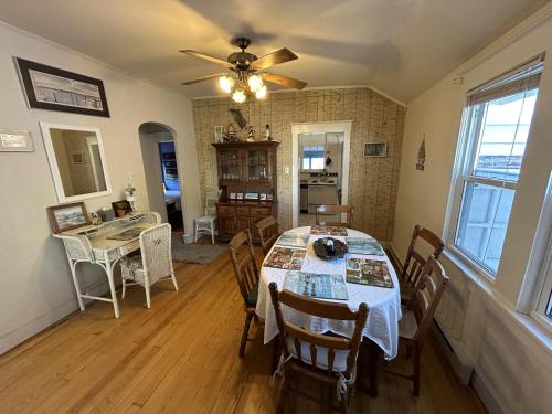 a dining room with a table with chairs and a ceiling fan at Cottage near beach and boards! in Ocean City