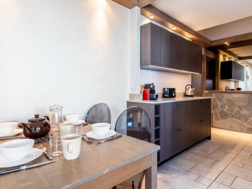 - une cuisine avec une table et des chaises en bois ainsi qu'un comptoir dans l'établissement Apartment Plein Soleil - Val Claret-3 by Interhome, à Tignes