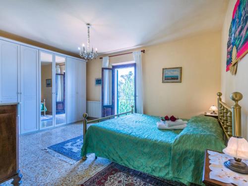 a bedroom with a bed with a green bedspread at Apartment L'Uccelliera-3 by Interhome in Canneto