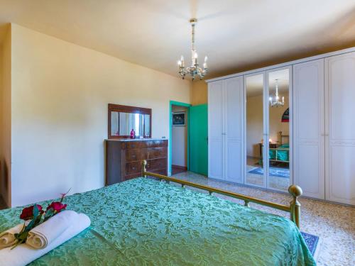 a bedroom with a bed with a green bedspread at Apartment L'Uccelliera-3 by Interhome in Canneto