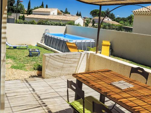 un patio avec une table et une piscine dans l'établissement Holiday Home A la porte d'Avignon by Interhome, à Laudun-l'Ardoise