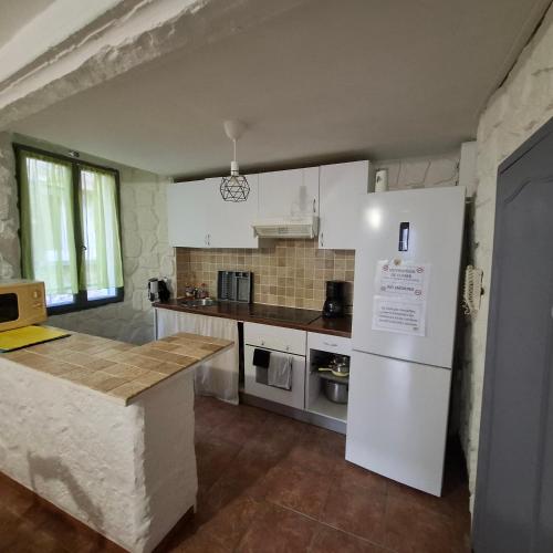 une cuisine avec un réfrigérateur blanc et un comptoir dans l'établissement Chez Bichette Brignoles, à Brignoles