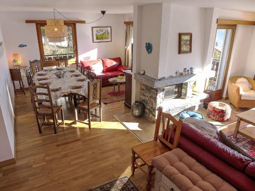una sala de estar con una mesa y una chimenea en Chalet Chalet Aglaia by Interhome, en Bluche