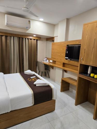 a hotel room with a bed and a tv at Galaxy Stays BKC in Mumbai