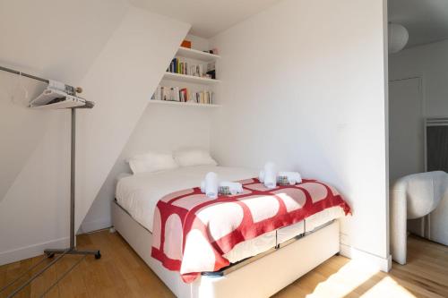 - une chambre dotée d'un lit avec une couverture rouge et blanche dans l'établissement Appartement Candie - Welkeys, à Paris