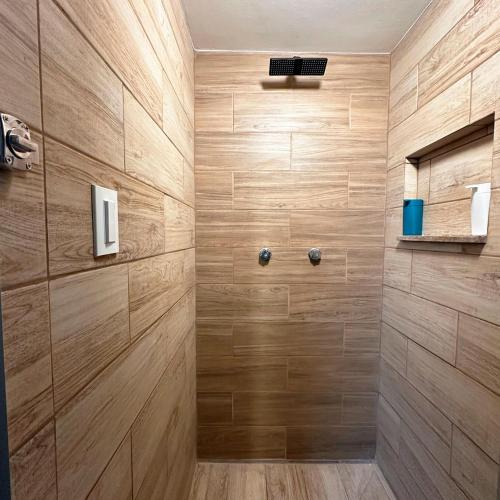 a bathroom with a shower with wooden walls at Cabina Dormitorio Polanco MP 3 in Mexico City