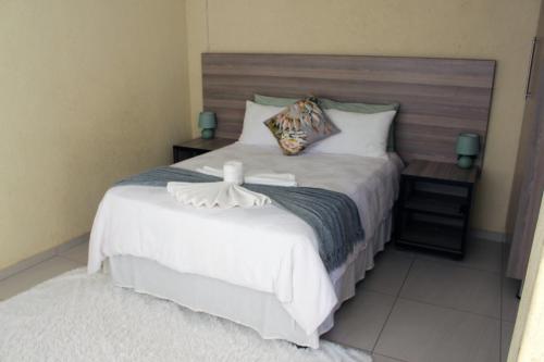 a bedroom with a large bed with a wooden headboard at Phendulani Lodge & Park in Calcutta