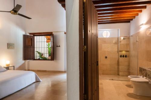 a bedroom with a bed and a glass shower at Karakali Boutique Hotel in Mompos