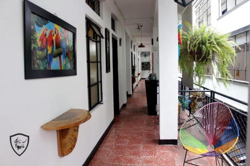a hallway with a bench and paintings on the wall at Hotel El Barcino in Neiva