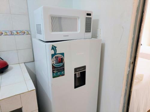 a microwave sitting on top of a refrigerator at Departamento 1 cerca del CAS y consulado,CRIT,Centro de Gobierno y Galerías Mall Cómodo, moderno y con entrada autónoma in Hermosillo