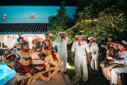 a group of men dressed in costumes standing next to a pool at Karakali Boutique Hotel in Mompos