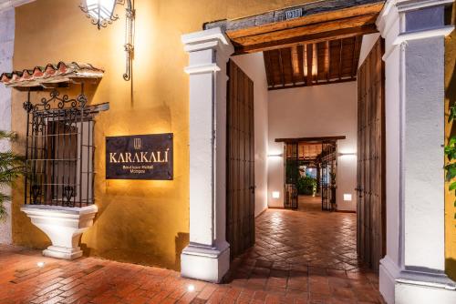 an entrance to a building with a sign on the wall at Karakali Boutique Hotel in Mompos