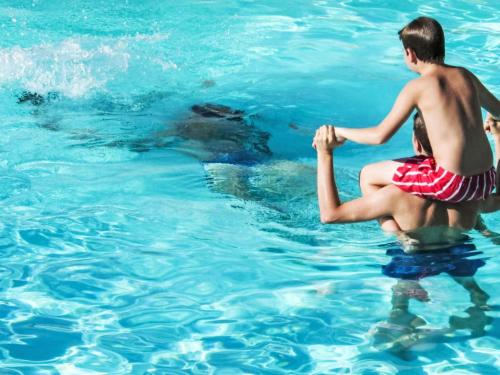 deux garçons jouant dans l'eau avec un ours dans l'établissement Apartment Grand Balcon- Piscine et proche du Port by Interhome, à Arzon