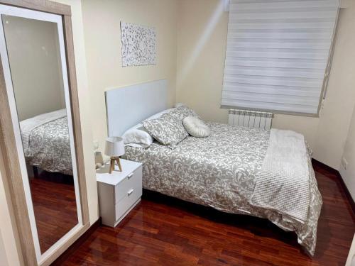 Un dormitorio con una cama y un espejo grande. en Encanto del Norte, en Villarcayo