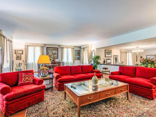 a living room with red couches and a coffee table at Holiday Home Villa Silvana by Interhome in Marcialla