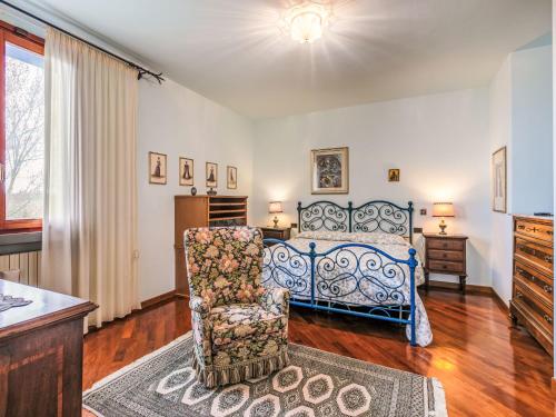 a bedroom with a bed and a chair at Holiday Home Villa Silvana by Interhome in Marcialla