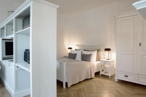 um quarto branco com uma cama e uma televisão em von Deska Townhouses - White House em Hamburgo