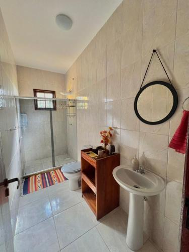 a bathroom with a shower and a sink and a toilet at Refugio Brisa do Campo - IG - SOLAR DO CAMPO in Iguaba Grande