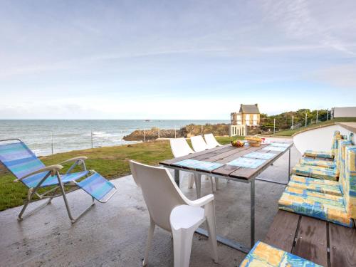 un patio avec des chaises et une table et l'océan dans l'établissement Apartment Ancadau by Interhome, à Saint-Malo