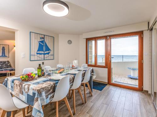 une salle à manger avec une table et des chaises et l'océan dans l'établissement Apartment Ancadau by Interhome, à Saint-Malo