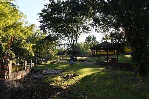 a person walking down a path with an umbrella at Tangaras da Serra in Macaé