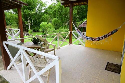 a porch with a hammock on the side of a house at Tangaras da Serra in Macaé