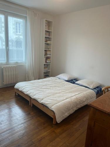 - un grand lit dans une chambre avec une étagère dans l'établissement Ty bihan glas, à Paimpol