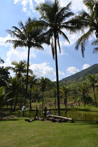 people sitting under palm trees in a park at Tangaras da Serra in Macaé