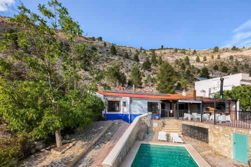 a house with a swimming pool next to a mountain at ALCALA DEL JUCAR, Casa rural Rio Tranquilo 1 -Piscina privada- in Tolosa