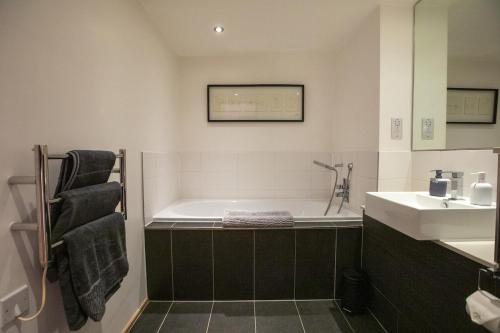 a bathroom with a bath tub and a sink at Luxury London Apartment in London