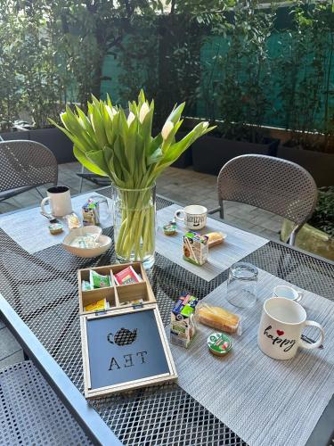a table with a vase of flowers and a sign on it at In CITY CENTER with PATIO in Como