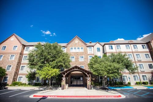 a large brick building with trees in front of it at Sonesta ES Suites Austin The Domain Area - Newly Renovated in Austin