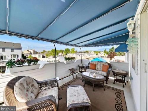 a patio with couches and tables on a balcony at Beach Haven West Has It All, Pool, Hot Tub in Beach Haven West