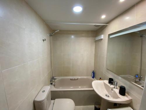a bathroom with a toilet and a sink and a tub at Apartment Madrid Ifema-Aeropuerto in Madrid