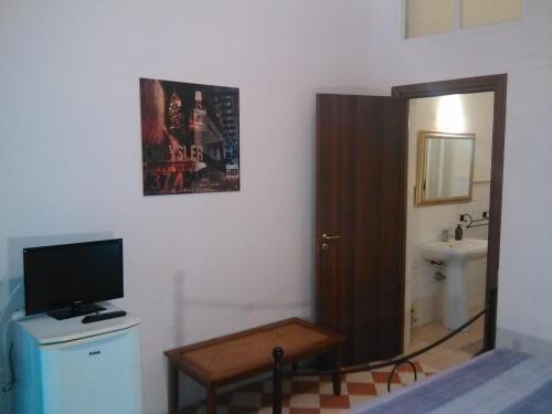 a bathroom with a television and a bathroom with a toilet at Ortigia Basic -Locazione Turistica in Siracusa