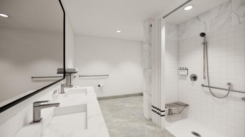 a white bathroom with two sinks and a shower at Kins Hotel in Los Angeles