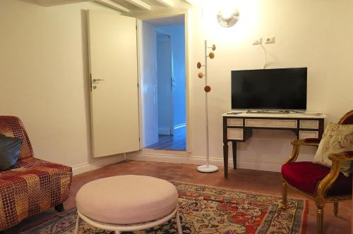 a living room with a television and a table with a stool at Casa Bardi in San Gimignano