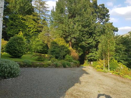 a gravel road in a garden with trees at Cuil Steading in Clachan