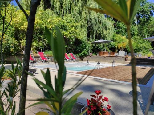 une piscine avec des chaises et une terrasse en bois dans l'établissement Maison Lili Paradis, à Saint-Savin