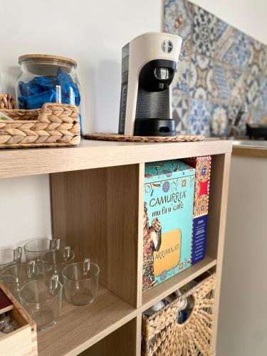 a coffee maker on top of a shelf with glasses at La Casa di Sara in Porto Empedocle