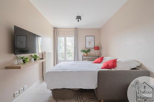 ein Schlafzimmer mit einem großen Bett mit roten Kissen in der Unterkunft Donald's Lodge - 5 minutes to Disneyland Paris in Magny-le-Hongre