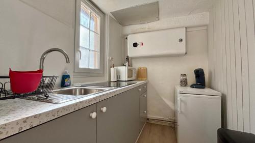 a small kitchen with a sink and a microwave at Le refuge autunois in Autun
