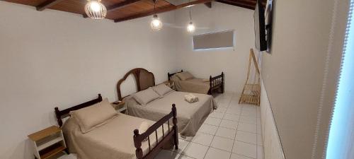 a room with two beds and a couch at Casa Cacau - Guest house a 700m metros de geriba in Armacao dos Buzios