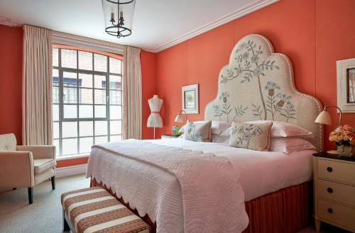 a bedroom with a large bed with orange walls at The Soho Hotel, Firmdale Hotels in London