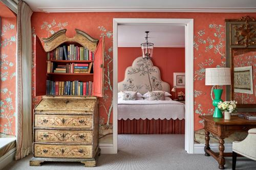 a bedroom with a bed and a mirror and a dresser at The Soho Hotel, Firmdale Hotels in London