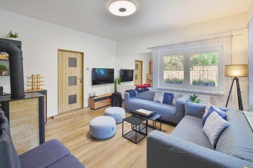 a living room with a blue couch and a fireplace at U 2 soviček - Krkonoše in Jablonec nad Jizerou