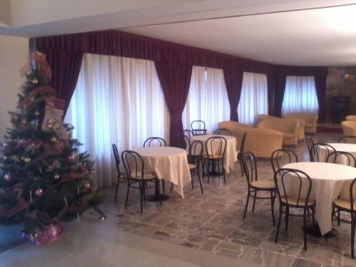 リッツァーノ・イン・ベルヴェデーレにあるHotel Miravalle 2000のクリスマスツリーのあるダイニングルーム、テーブルと椅子