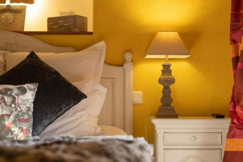 a bedroom with a bed with a lamp on a night stand at Le Moulin de Beaunette in Grane