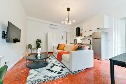 un salon avec un canapé blanc et une table dans l'établissement Flavie - Hypercentral Cosy Modern - by TGB, à Ajaccio