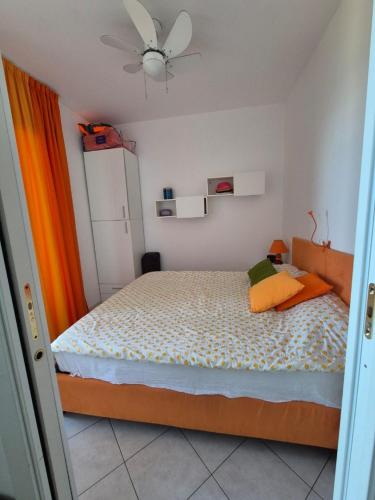 une chambre avec un lit et un ventilateur de plafond dans l'établissement Appartement Marine de Sant Ambrogio, à Lumio